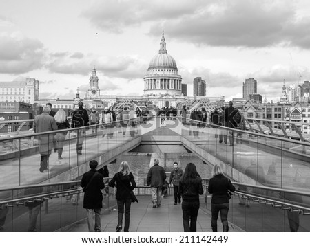LONDON, ENGLAND, UK - MARCH 04, 2009: Tourists crossing the Millennium Bridge linking the City of London with the South Bank between St Paul Cathedral and Tate Modern art gallery