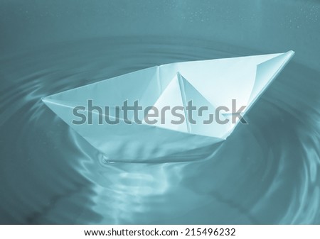 A picture of Paper ship in water - cool cyanotype