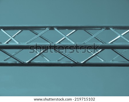 Steel truss beam structure over blue sky background - cool cyanotype