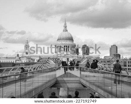 LONDON, ENGLAND, UK - MARCH 04, 2009: Tourists crossing the Millennium Bridge linking the City of London with the South Bank between St Paul Cathedral and Tate Modern art gallery