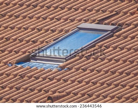 Detail of red roof tiles and roof window