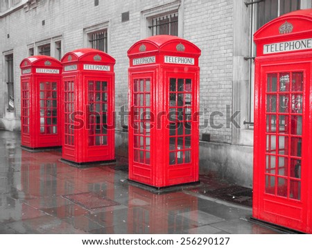Red telephone box in London over desaturated black and white background