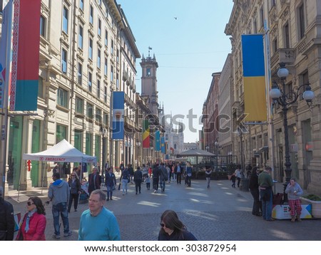 MILAN, ITALY - MARCH 28, 2015: Tourists walking by the flags from all countries of the world on show in Milan city centre as part of the Expo Milano 2015 international exhibition
