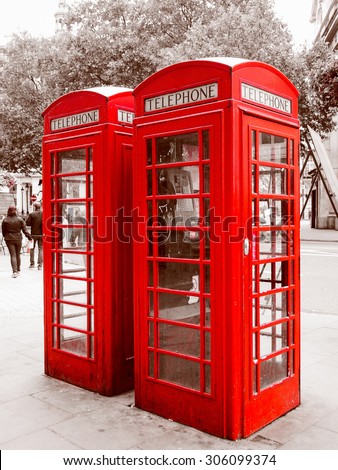 Vintage looking Red telephone box in London over desaturated black and white background