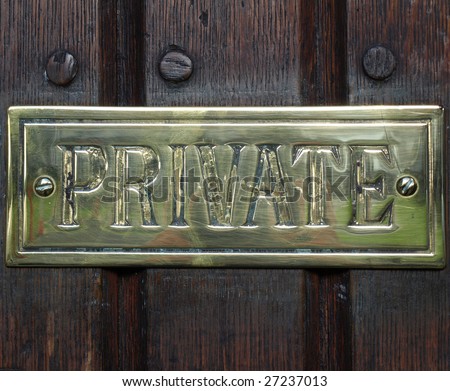 Private label on golden plate over a wooden door