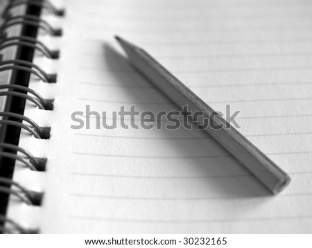 Blank notebook page with pencil on top