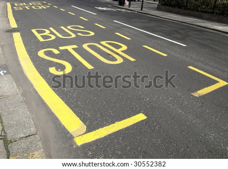 Yellow painted bus stop sign on a street