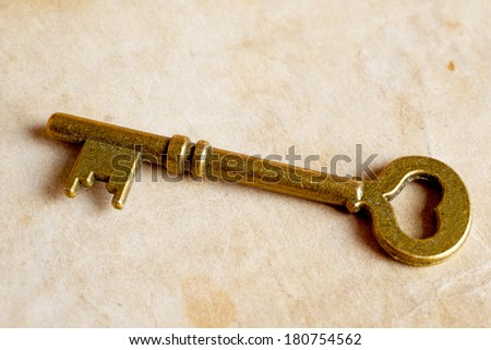 distressed vintage key with old paper texture overlay