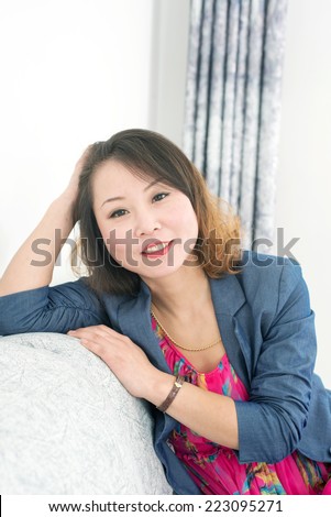 Portrait of thinking woman indoor. Beautiful asian girl
