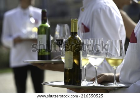Waiters are serving vine at a wedding outdoor party