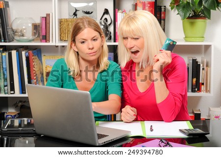 Senior woman and caregiver with laptop and credit card