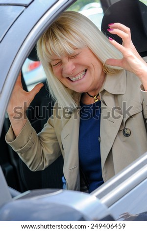A senior woman angry at the wheel of her car.