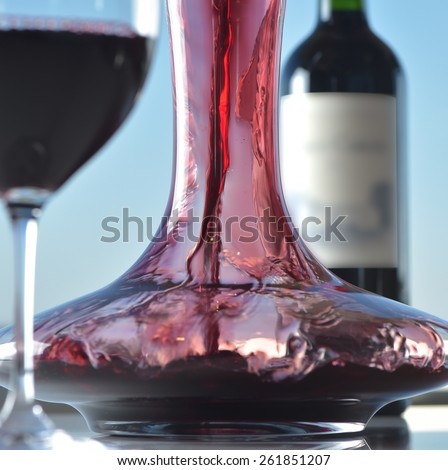 Waiter pouring the wine in a glass with a carafe
