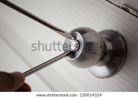 Thief with a bar of iron in the hand to open a door