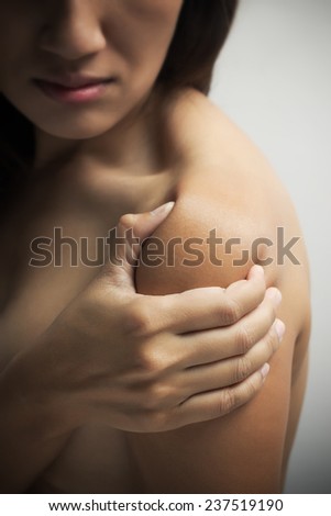 Woman pressing her hand against a painful shoulder