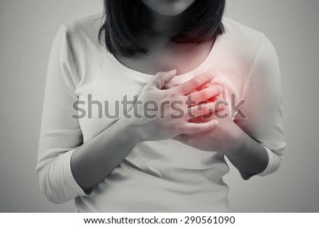 Woman is clutching her chest, acute pain possible heart attack