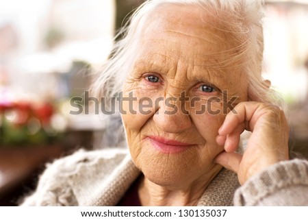 Portrait of the smiling elderly woman, sitting outdoor