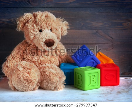 Teddy Bear toy and cubes on wood background