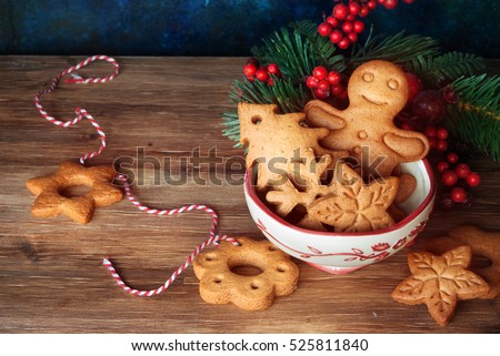 Gingerbread and christmas cookies in a bowl and festive decor on wooden background with a place for text
