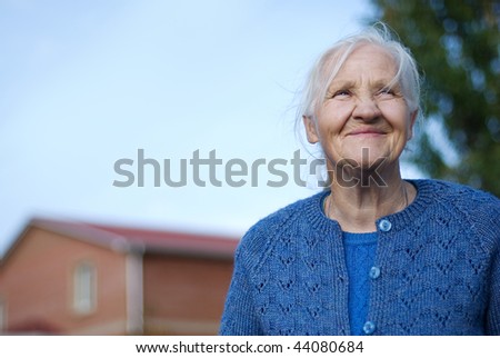 Happy elderly woman, building on the background