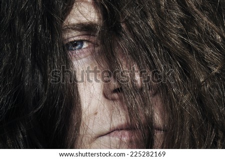 An angry man with long hair, rock\'n\'roll or devil sign in the eye looking on you