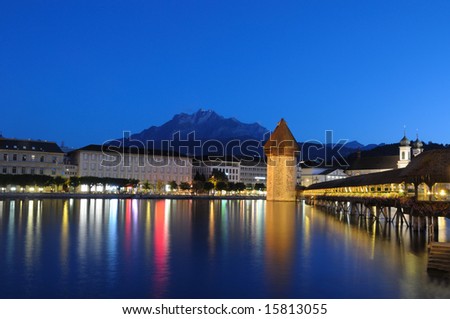 Famous Chapel Bridge and Mount Pilatus in Lucerne, Switzeland on a clear summer night.