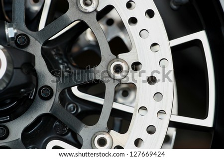 Motorcycle wheel in black and white with ABS brakes.