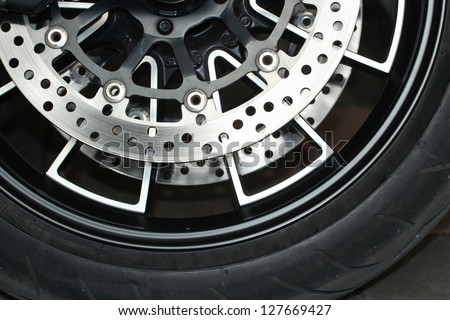 Motorcycle wheel in black and white with ABS brakes.