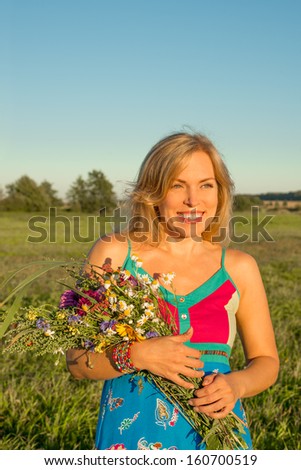 Woman with wild flowers smiling