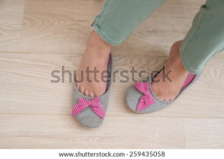 Woman feet with slippers on the floor