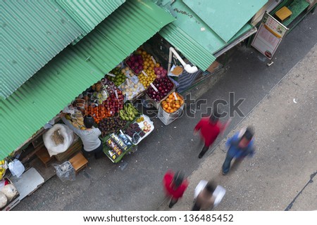 HONG KONG , CHINA - MARCH 22 : Fruit Stall in Central district on March 22, 2013 in Hong Kong. People buying and selling fruit, meat, fish and vegetable between buildings in Central district.