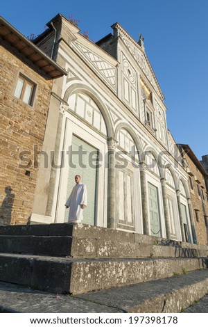 FLORENCE , ITALY - MAY 10 : A monk walked across the facade of San Miniato al Monte on May 10, 2014 in Florence, Italy. The church standing atop one of the highest points in the city.