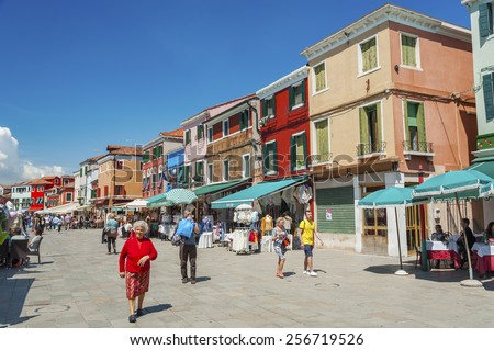 BURANO, ITALY - MAY 08, 2014: Tourist on the street Baldassare Galuppi on the famous island Burano, Venice, Italy. Venice and the Venetian lagoon are on the UNESCO World Heritage List.