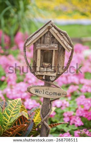Ornate Wooden Mailbox with welcome sign in colorful garden