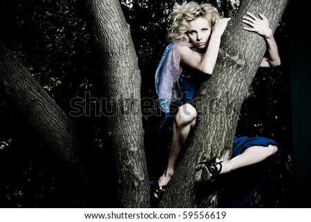 Portrait of a beautiful young sexy woman on a tree