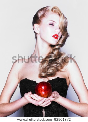 Young pretty woman in a fashionable dress with apple