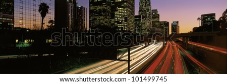 This is the Harbor Freeway with rush hour traffic at sunset. The yellow and red streaked lights from the cars are on the freeway.