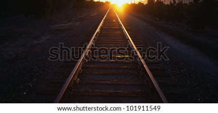 These are railroad tracks that go off into infinity at sunrise. The sun is at the end of the tracks at the horizon.