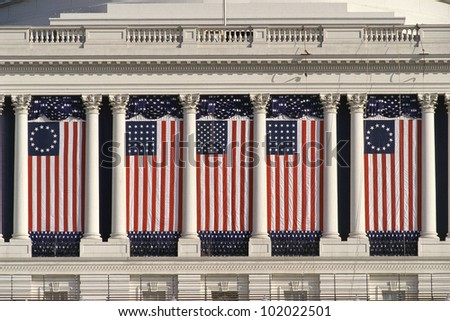 US Capitol Building with American flags draped between columns
