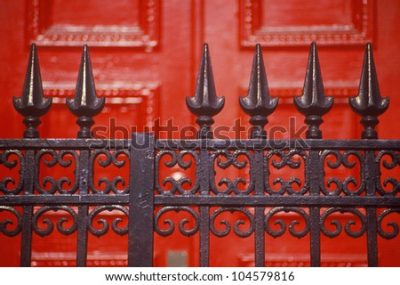 Spike wrought iron fence in front of red door