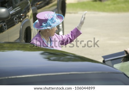 Her Majesty Queen Elizabeth II in bright purple outfit and hat, waving to the crowd as she enters Presidential Limousine in Williamsburg Virginia, May 4, 2007