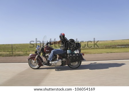 Motorcyclist with American flag bandana driving towards Sturgis South Dakota for the 67th Annual Sturgis Motorcycle Rally, Sturgis, South Dakota, August 6-12, 2007
