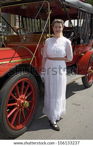 JUNE 2008 - Woman in Victorian dress standing in front of antique car in Santa Paula, CA