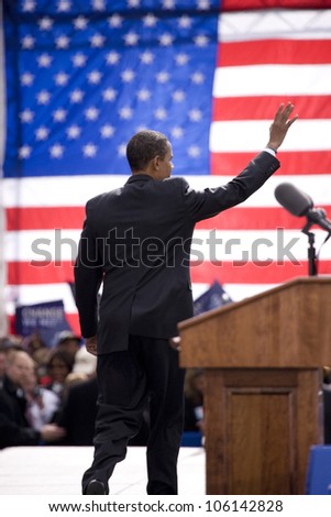 Presidential Candidate Barack Obama waves to crowd as he is framed against American Flag at early vote for change Presidential rally October 29, 2008 at Halifax Mall, Government Complex in Raleigh, NC
