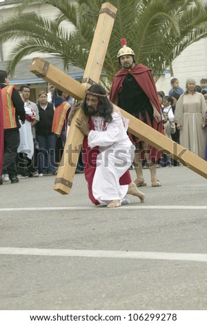 An actor portraying Jesus Christ carrying a cross past crowds on Good Friday, Easter, during the Passion play, Oxnard, California, April 6, 2007