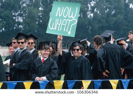 CIRCA 1990 - UCLA graduate holding up Now What? sign at graduation ceremony