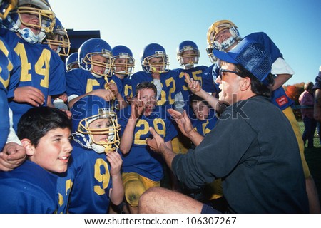 CIRCA 1994 - Coach giving youth football team a pep talk in Connecticut