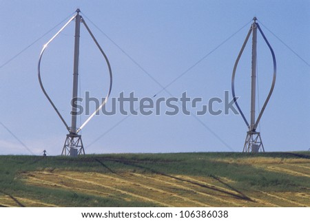 Two vertical-axis wind turbines standing on ground