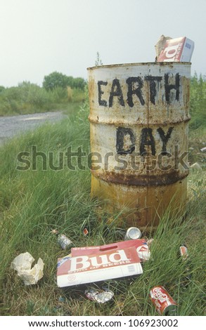 CIRCA 1990 - Cardboard beer cartons on the ground next to a trash can with the words \