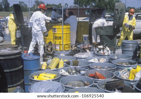 CIRCA 1990 - Workers handling toxic household wastes at waste cleanup site on Earth Day at the Unocal plant in Wilmington, Los Angeles, CA